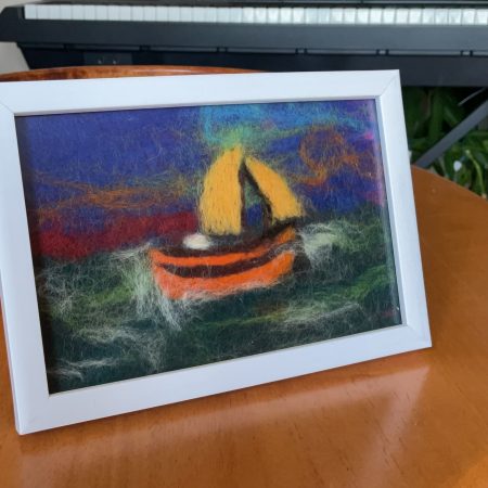 Needle felted fishing boat retreating from a storm.