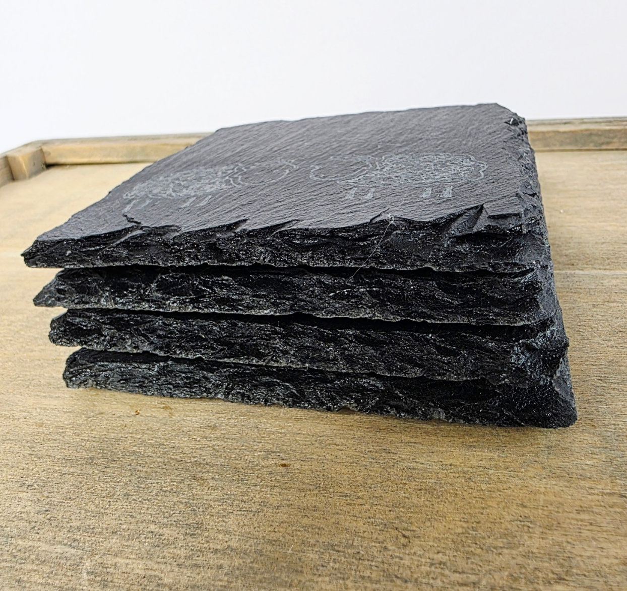 Stack of black slate tiles on a wooden surface
