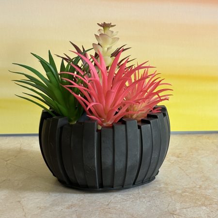 Irregular pot with imitation succulents available in others colours .