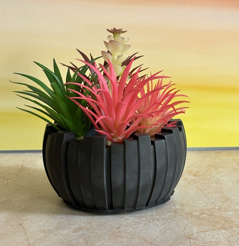 Irregular pot with imitation succulents available in others colours .