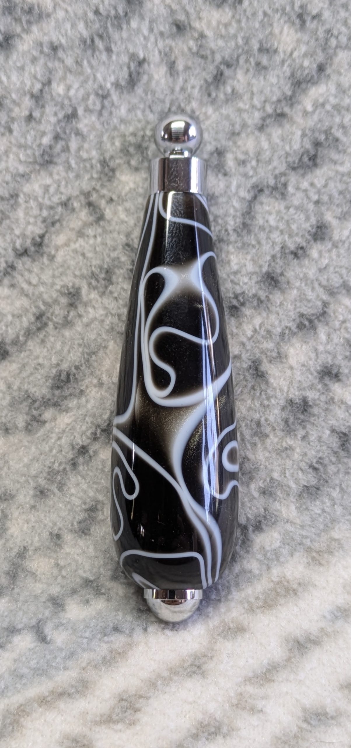 Light switch pull pendant made from black acrylic with white swirls and chrome fittings