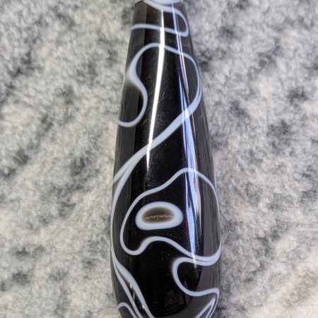 Light switch pull pendant made from black acrylic with white swirls and chrome fittings