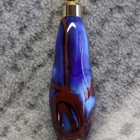 Light switch pull pendant made from blue acrylic with red swirls and gold coloured fittings