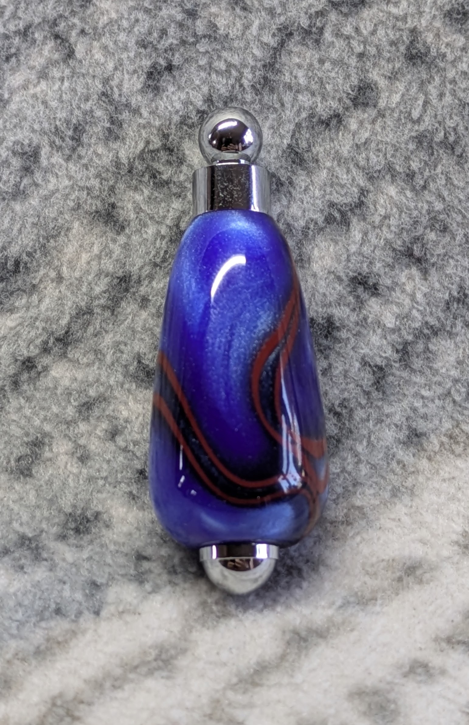Light switch pull pendant made from blue acrylic with red swirls and chrome fittings