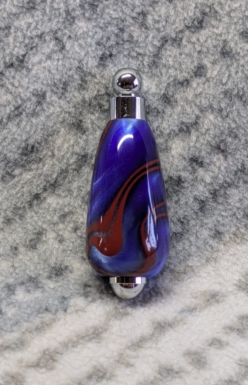 Light switch pull pendant made from blue acrylic with red swirls and chrome fittings