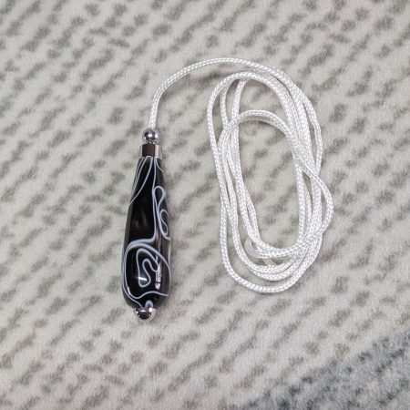 Light switch pull pendant made from black acrylic with white swirls and chrome fittings
