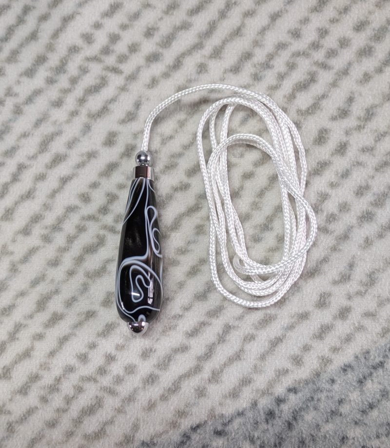 Light switch pull pendant made from black acrylic with white swirls and chrome fittings