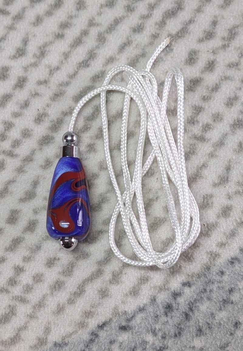 Light switch pull pendant made from blue acrylic with red swirls and chrome fittings