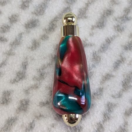 Light switch pull pendant made from red, green and gold acrylic with gold coloured fittings
