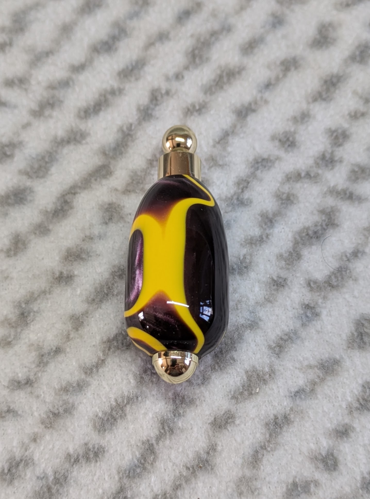 Light switch pull pendant made from Plum coloured acrylic with yellow lines