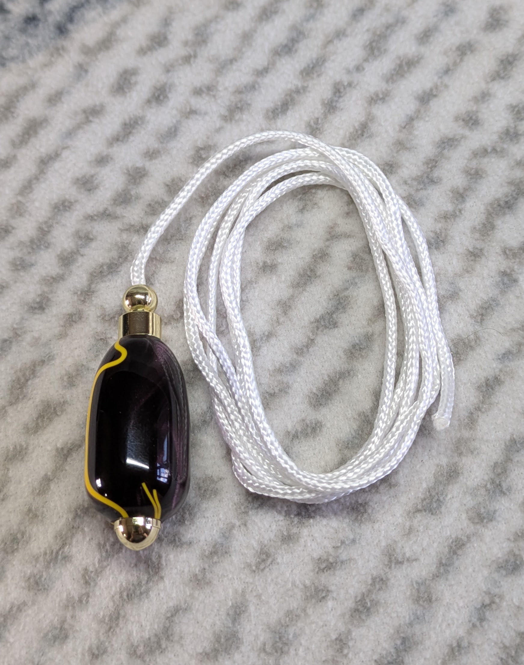 Light switch pull pendant made from Plum coloured acrylic with yellow lines