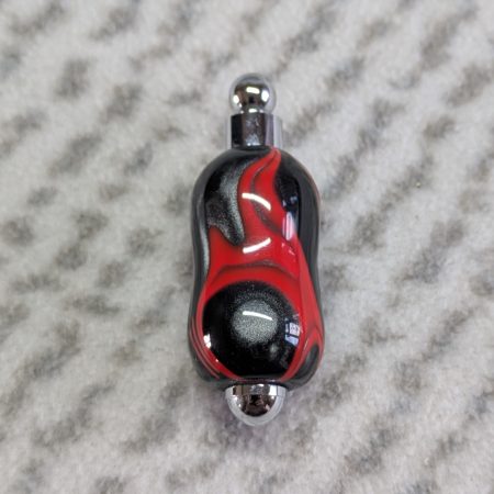 Light switch pull pendant made from shimmering black acrylic with red lines and chrome fittings