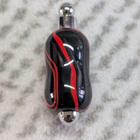 Light switch pull pendant made from shimmering black acrylic with red lines and chrome fittings