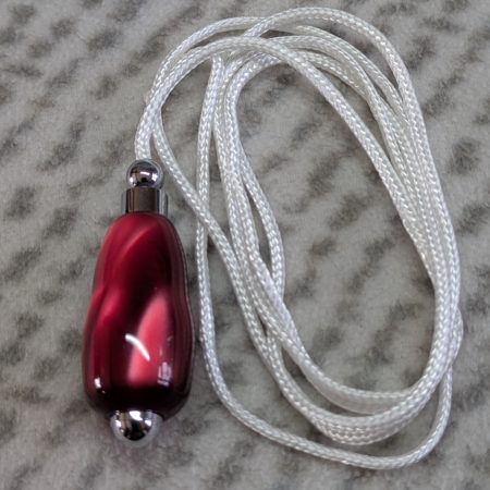 Light switch pull pendant made from shimmering red acrylic