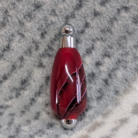 Light switch pull pendant made from shimmering red acrylic and chrome fittings