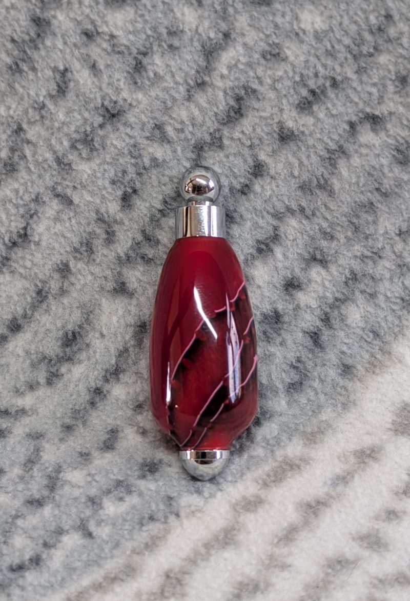 Light switch pull pendant made from shimmering red acrylic