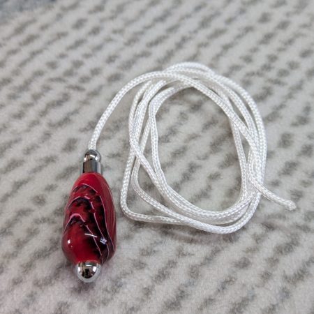 Light switch pull pendant made from shimmering red acrylic