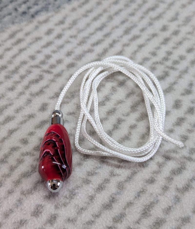Light switch pull pendant made from shimmering red acrylic