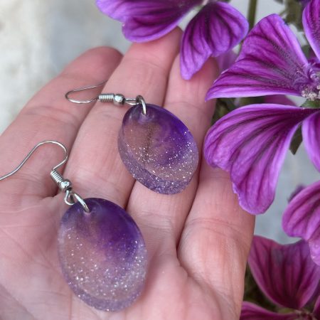 Resin oval earrings with silver glitter and touch if purple