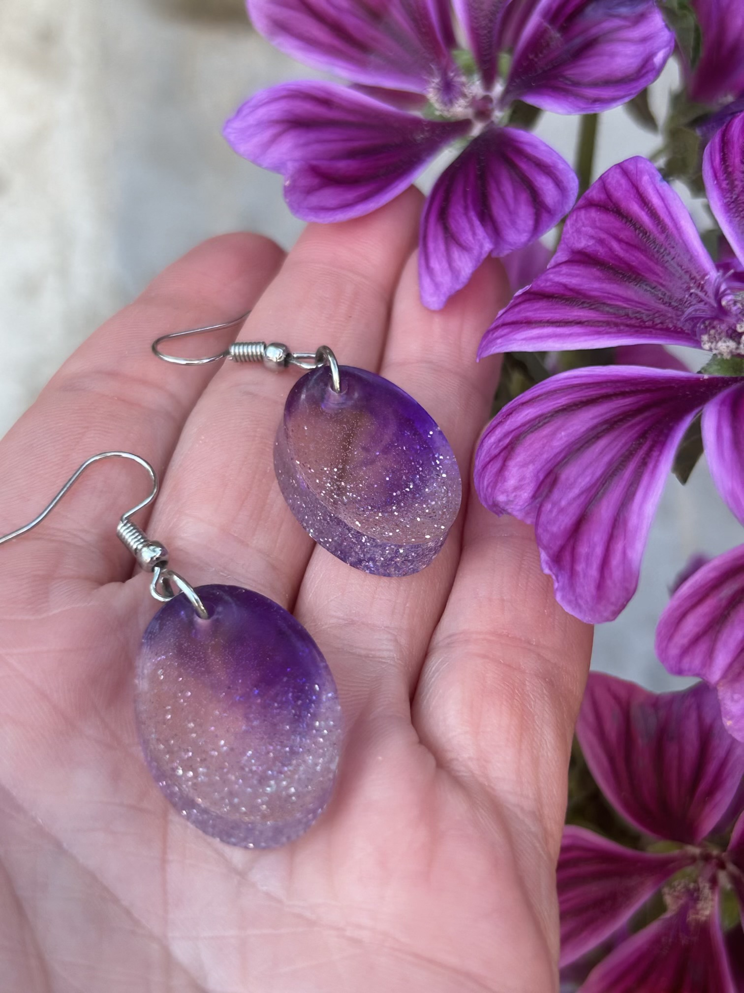 Resin oval earrings with silver glitter and touch if purple