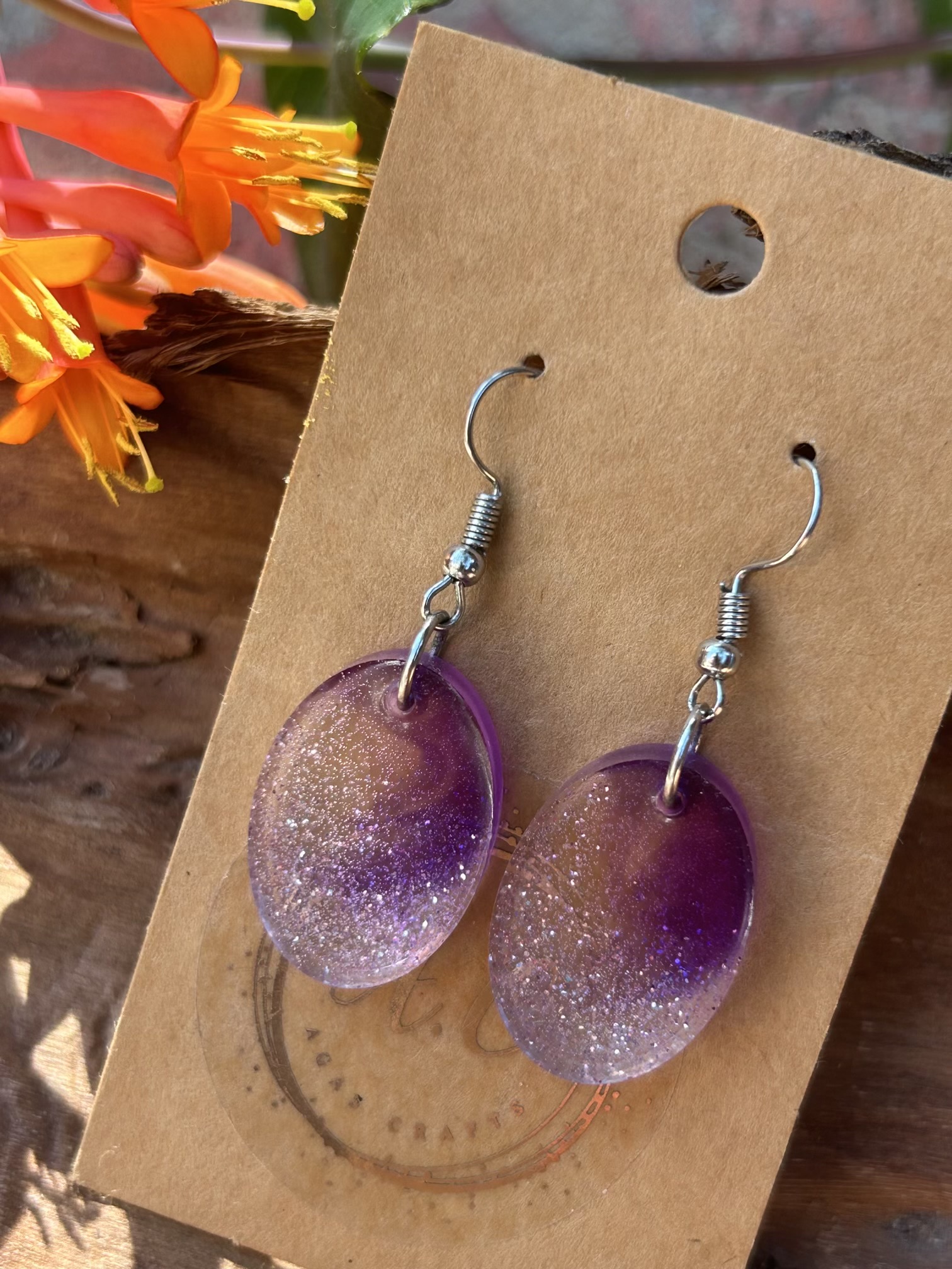 Resin oval earrings with silver glitter and touch if purple