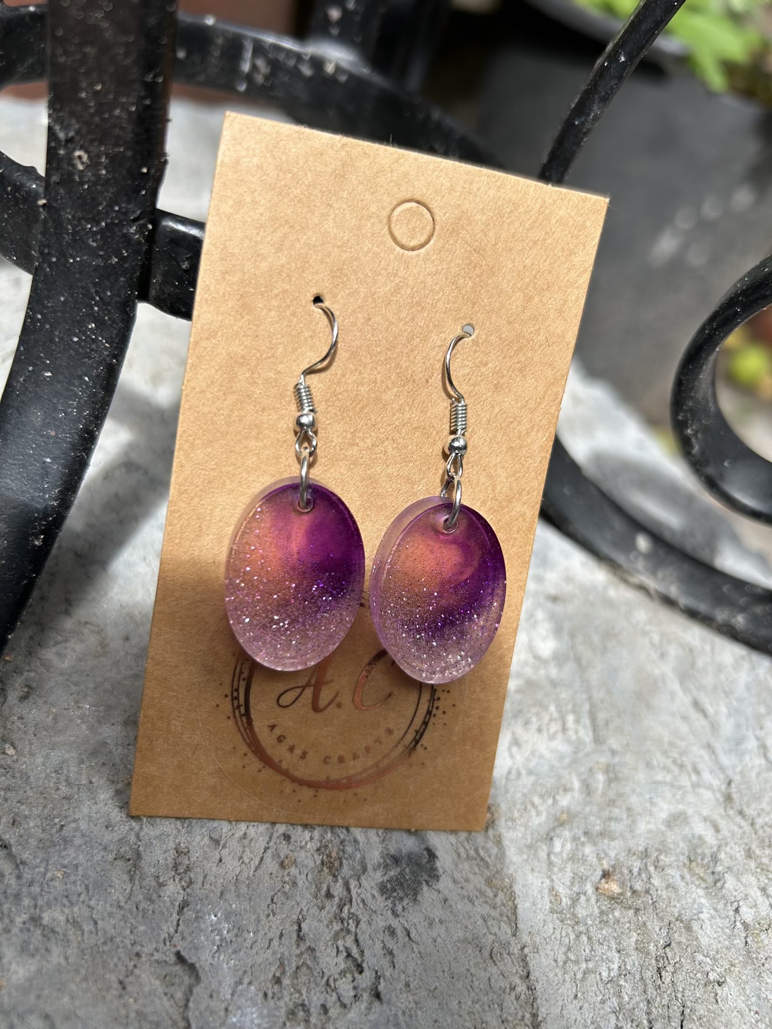 Resin oval earrings with silver glitter and touch if purple
