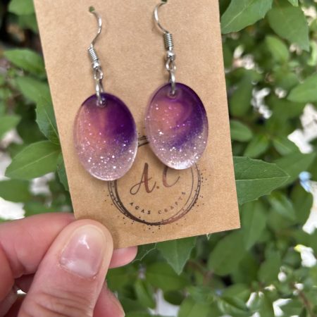 Resin oval earrings with silver glitter and touch if purple