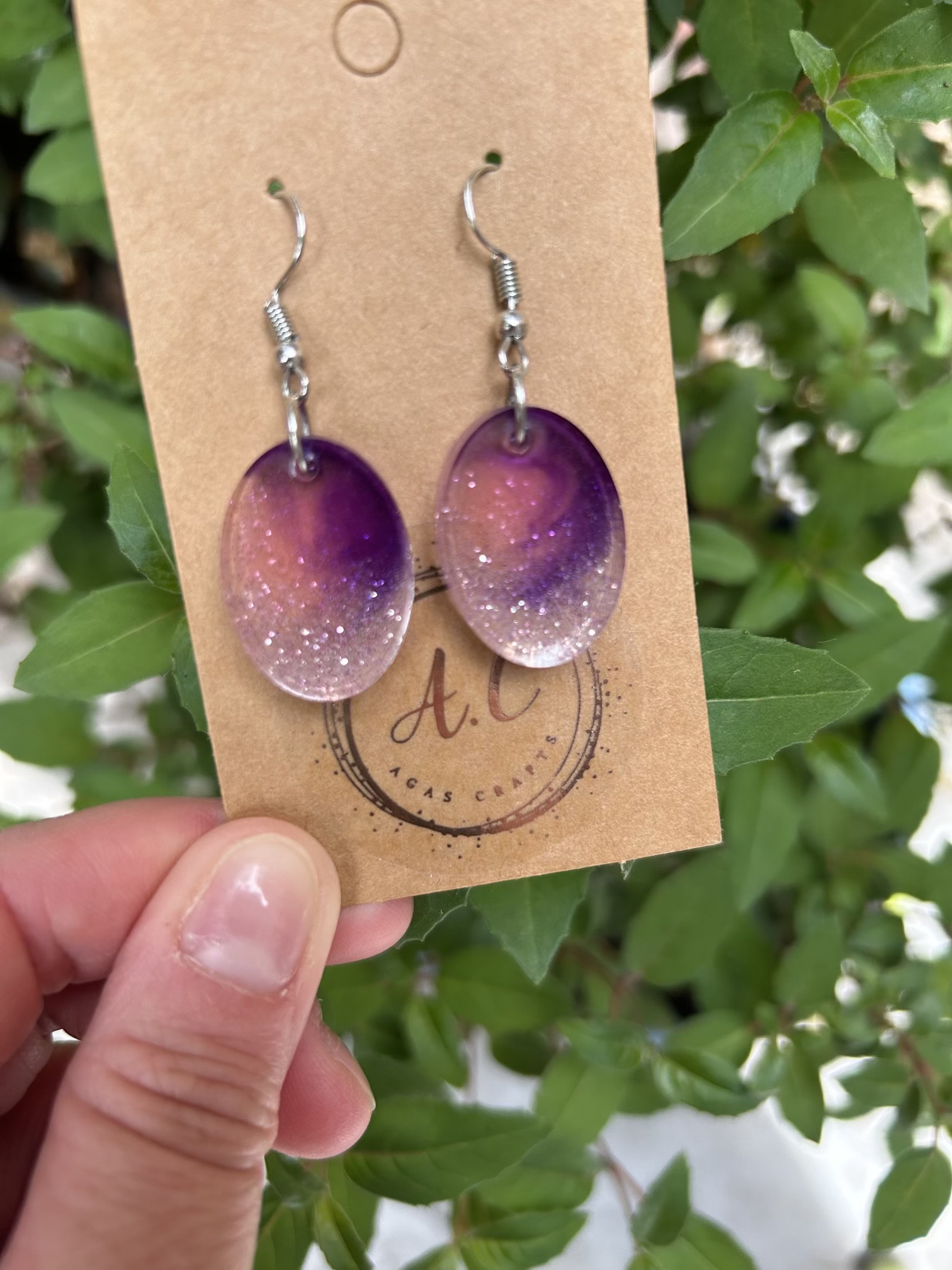 Resin oval earrings with silver glitter and touch if purple