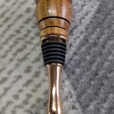 Hand turned bottle stopper made from iroko with a 24 carat gold plated teardrop base