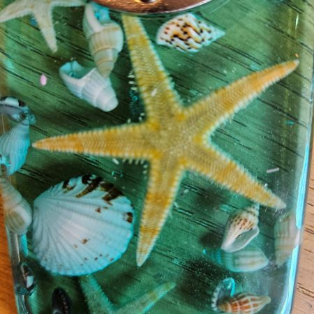 Beach themed nautical resin bottle opener with starfish & shells.