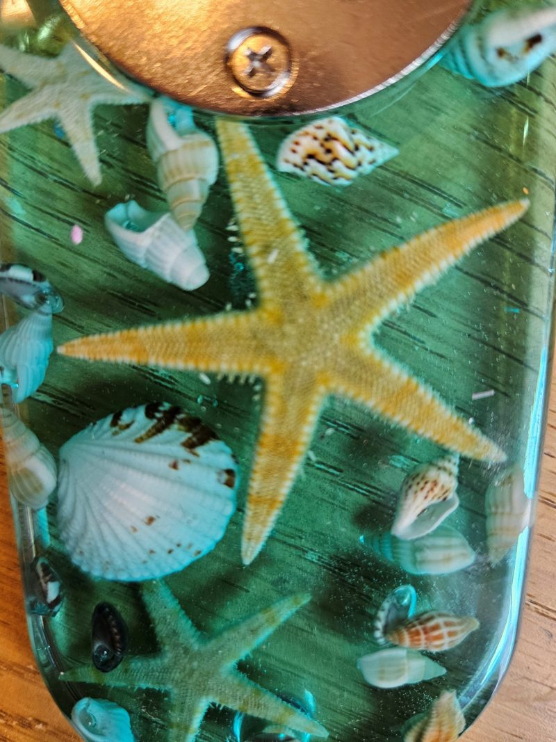 Beach themed nautical resin bottle opener with starfish & shells.