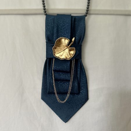 Handmade, elegant, shiny blue necktie accessory adorned by a beautiful golden leaf pendant