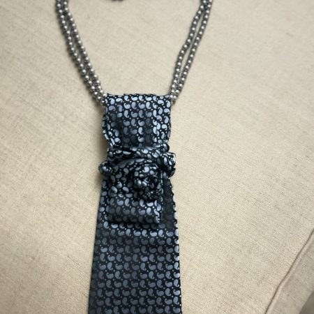 Handmade, necktie accessory in a lovely, funky blue pattern tied with dark silver pearls
