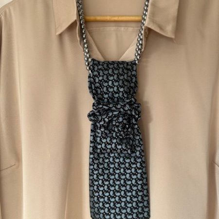 Handmade, necktie accessory in a lovely, funky blue pattern tied with dark silver pearls