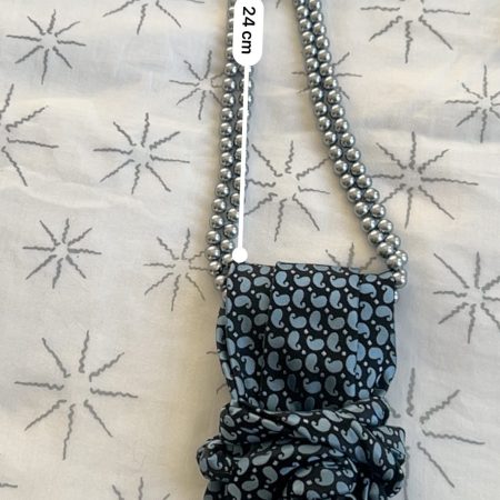 Handmade, necktie accessory in a lovely, funky blue pattern tied with dark silver pearls
