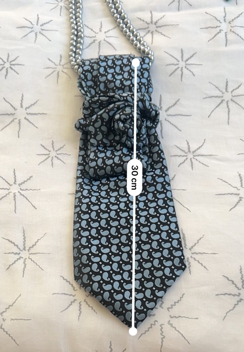 Handmade, necktie accessory in a lovely, funky blue pattern tied with dark silver pearls