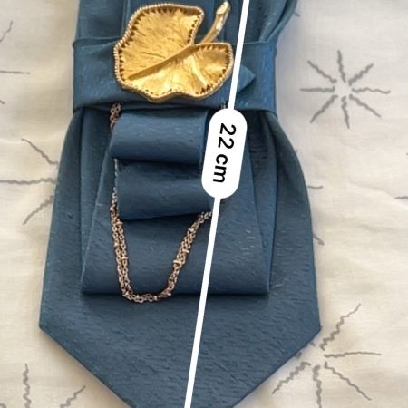 Handmade, elegant, shiny blue necktie accessory adorned by a beautiful golden leaf pendant