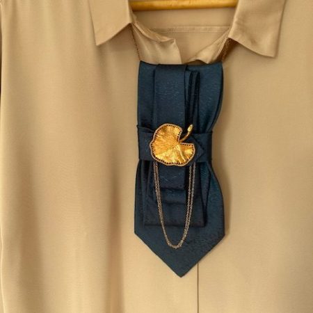 Handmade, elegant, shiny blue necktie accessory adorned by a beautiful golden leaf pendant