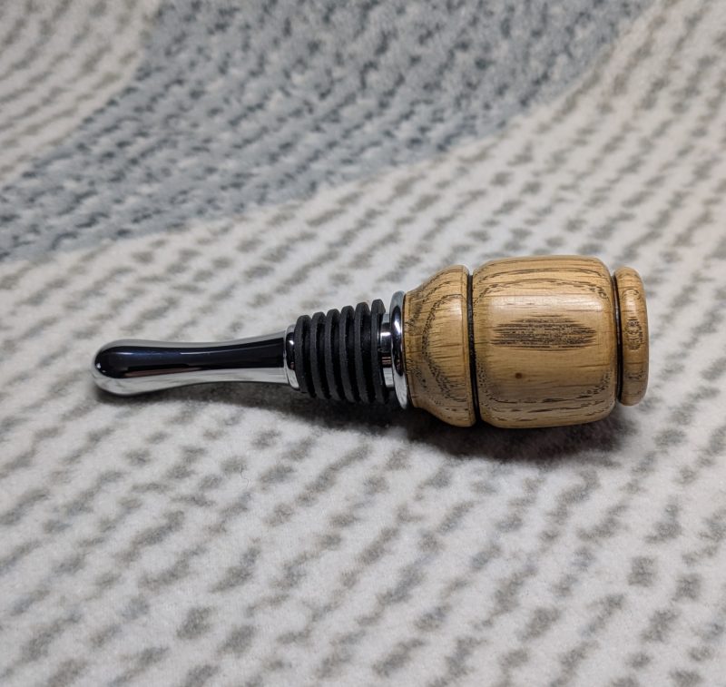 Hand turned bottle stopper made from oak with a chrome teardrop base