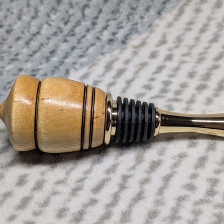 Hand turned birch bottle stopper with a gold plated teardrop base