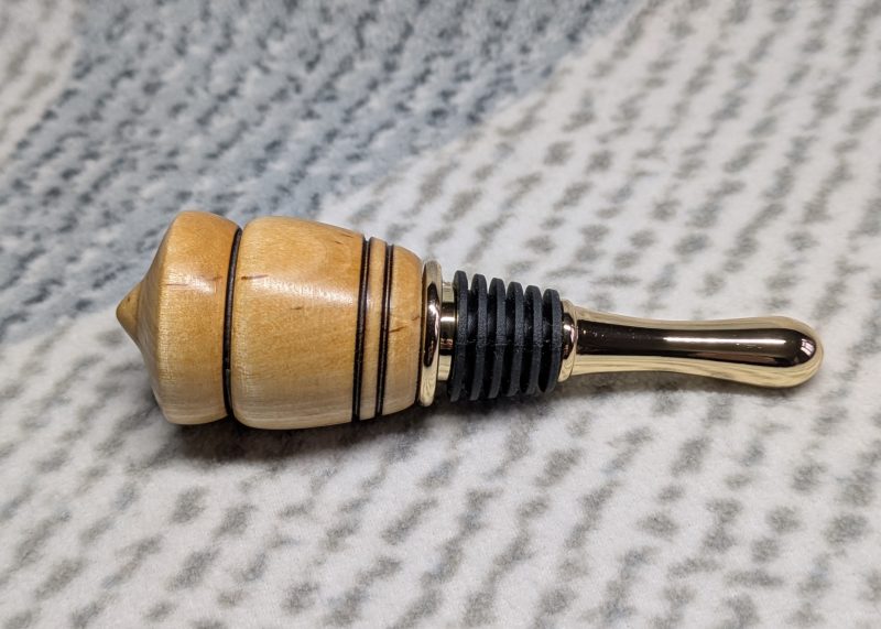 Hand turned birch bottle stopper with a gold plated teardrop base