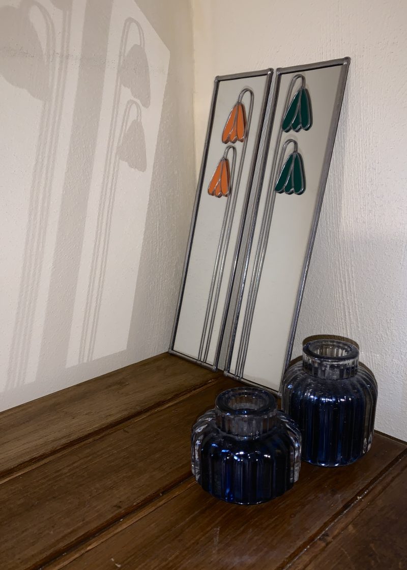 Stained glass effect mirrors with green and orange flowers.