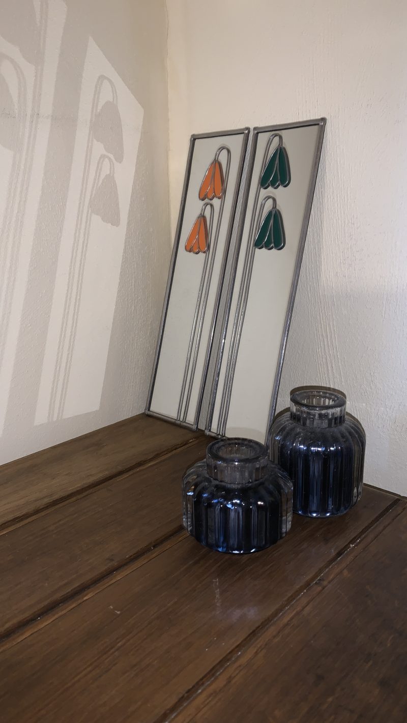 Stained glass effect mirrors with green and orange flowers.