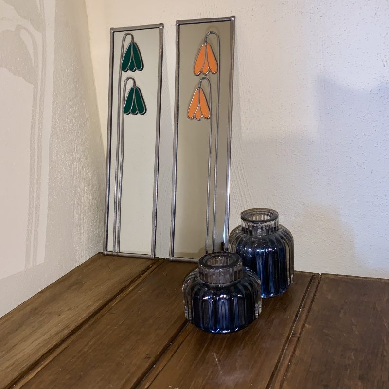 Stained glass effect mirrors with green and orange flowers.