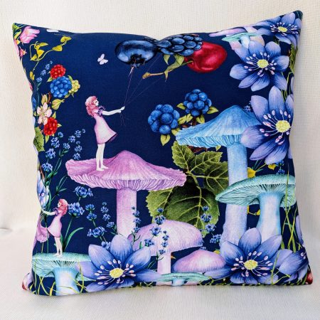 Illustrated cushion cover featuring a girl standing on a mushroom holding berry shaped balloons surrounded by flowers and butterflies on a navy background.