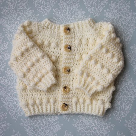 Crochet Baby Cardigan in a Cream Colour and Features a Bobble Design