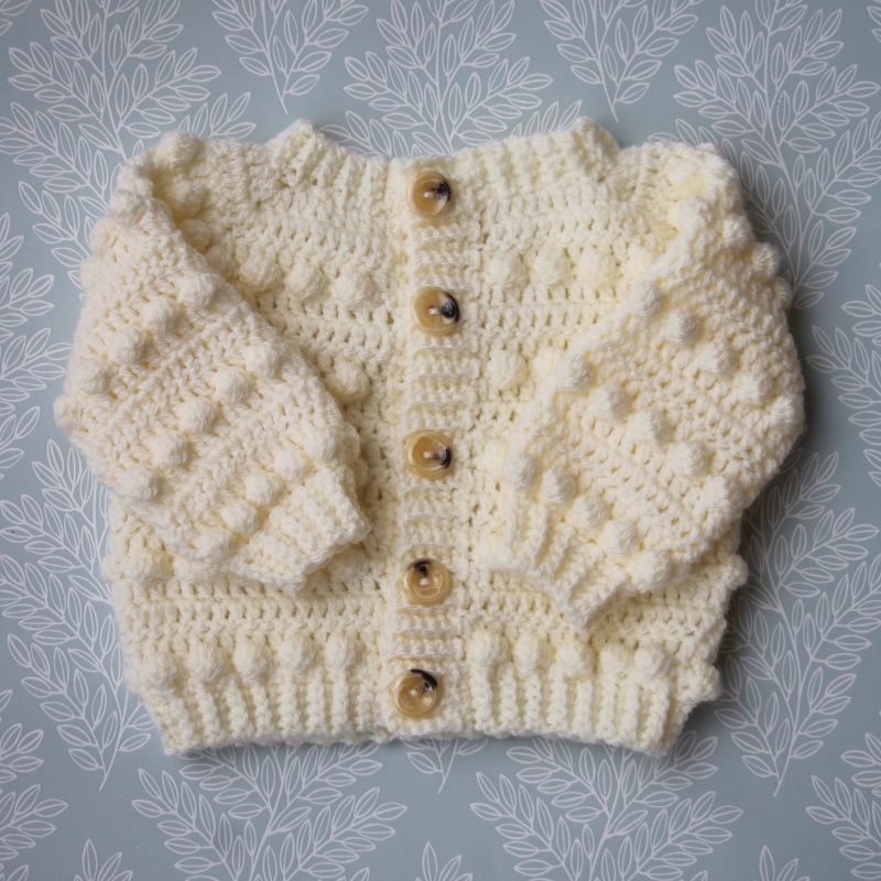 Crochet Baby Cardigan in a Cream Colour and Features a Bobble Design