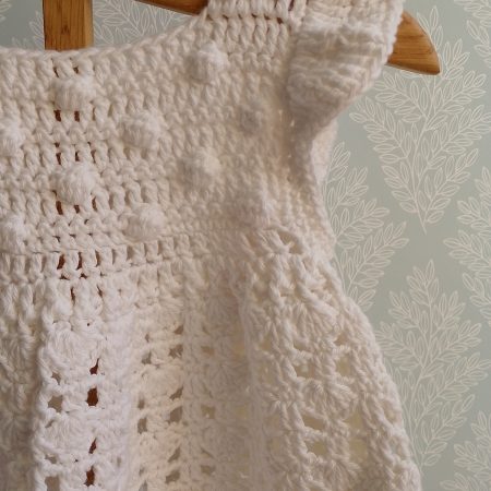 Sleeveless Sun Dress featuring bobbles on front bib and a ruffle shoulder