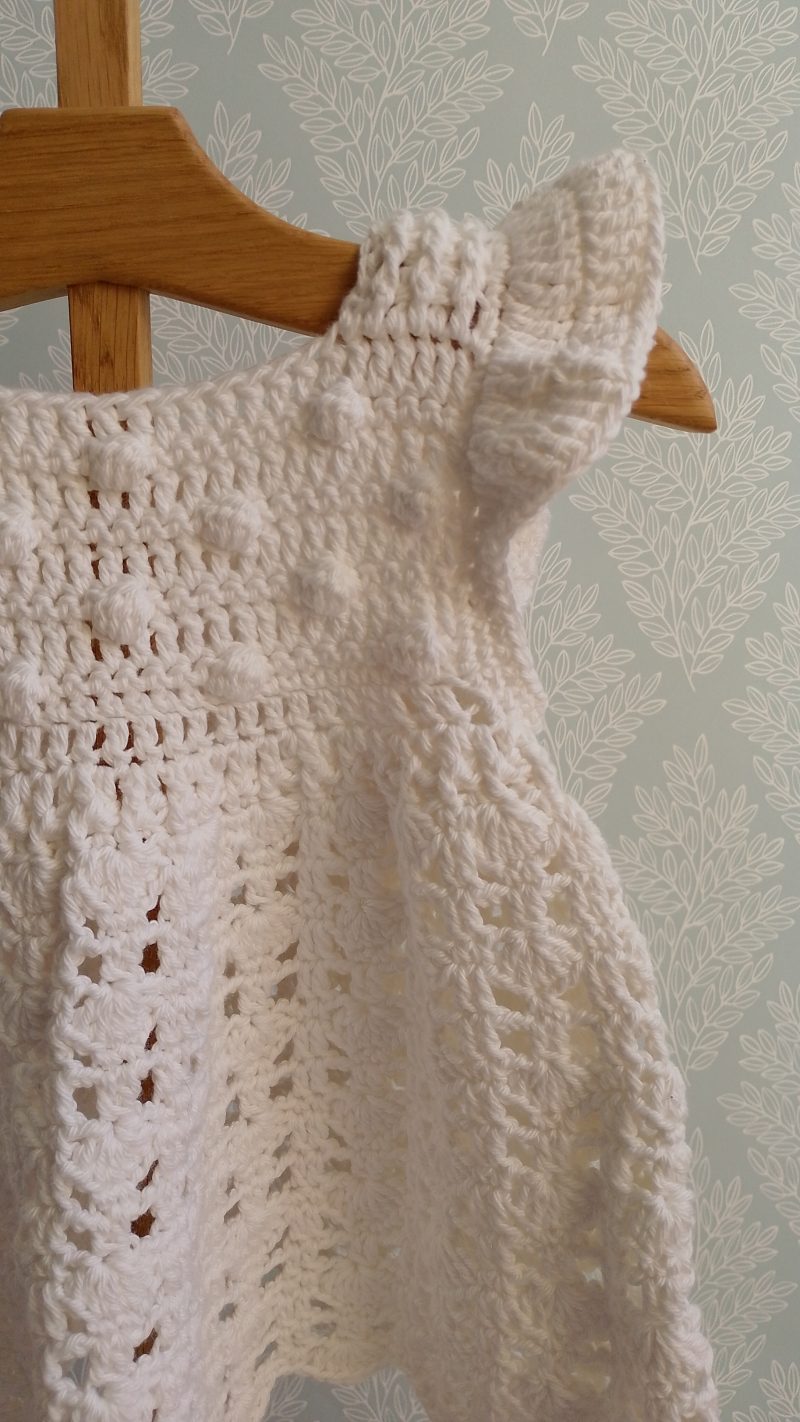 Sleeveless Sun Dress featuring bobbles on front bib and a ruffle shoulder