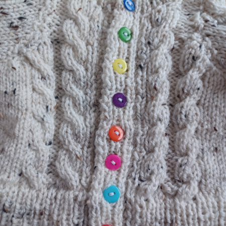 Cabled cardigan in soft yarn giving a tweed look.
